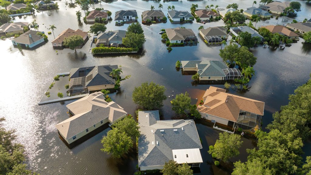 Home partially submerged in floodwater, representing the financial risk for property owners without adequate flood insurance coverage.