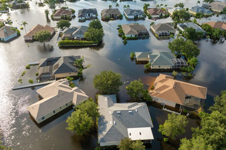 Home partially submerged in floodwater, representing the financial risk for property owners without adequate flood insurance coverage.